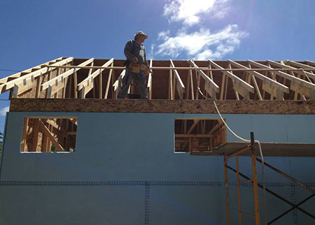 house being built, roof exposed with person working on it
